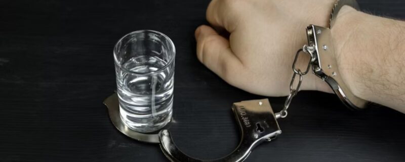 Close-up of a man’s hand, previously handcuffed to a drink, now freed.