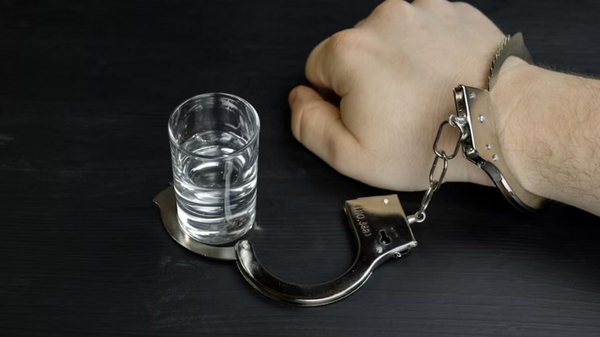 Close-up of a man’s hand, previously handcuffed to a drink, now freed.