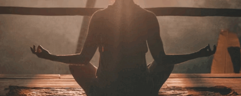 Woman performing yoga at dusk, looking serene and enlightened as the late afternoon sun casts a warm glow on her.
