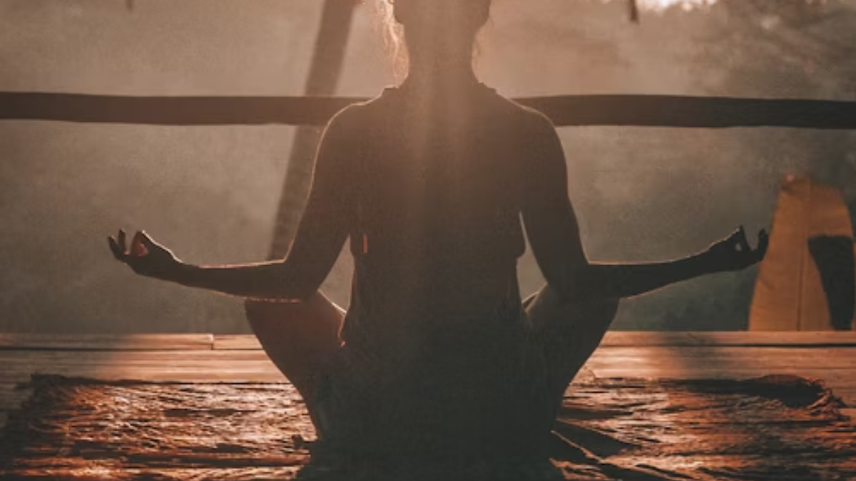 Woman performing yoga at dusk, looking serene and enlightened as the late afternoon sun casts a warm glow on her.