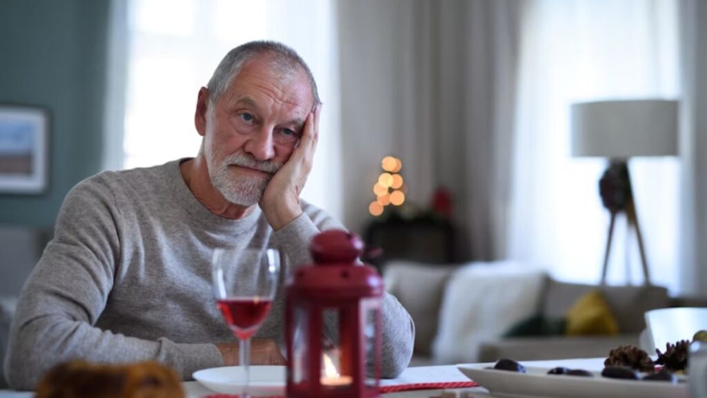 The Science of Addiction: Why It’s More Than Just “Willpower” 3 Science of addiction, a man leans his cheek on his palm while sitting at a table, looking contemplative with several drinks in front of him.