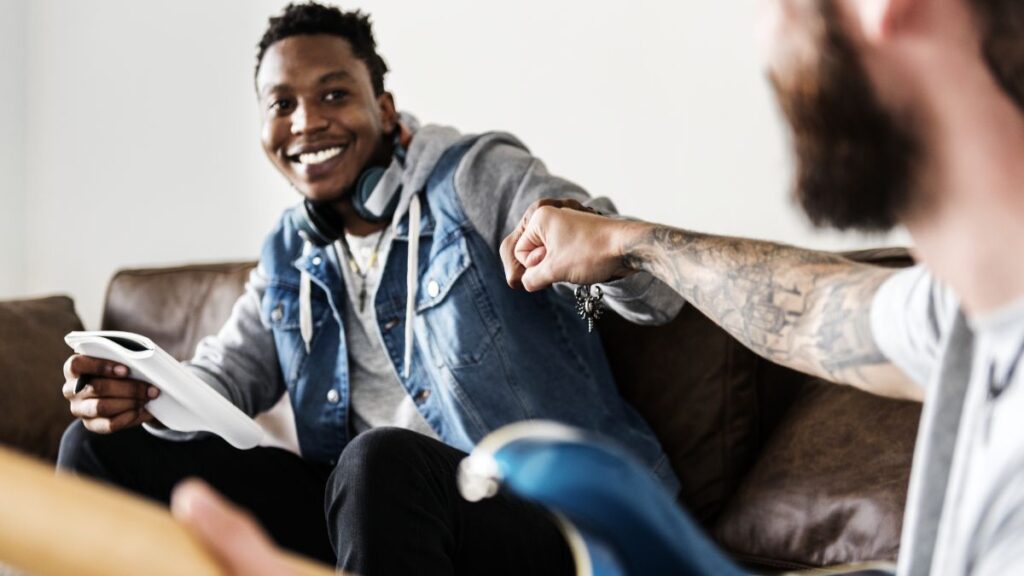 Substance Use Disorder: A man in central focus presses his knuckles against another man in the foreground, whose back faces the camera.